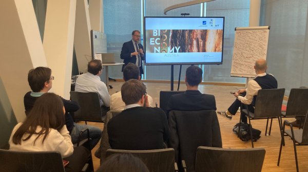 Vortragsraum mit vortragenden Personen und Publikum