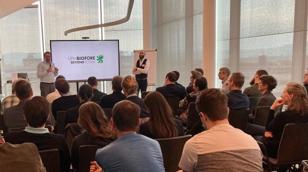 Vortragsraum mit vortragenden Personen und Publikum