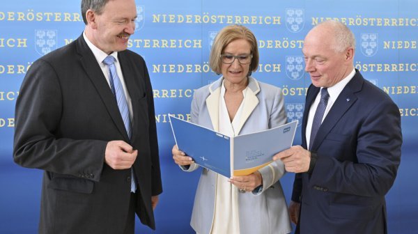 Drei Personen schauen Broschüre an