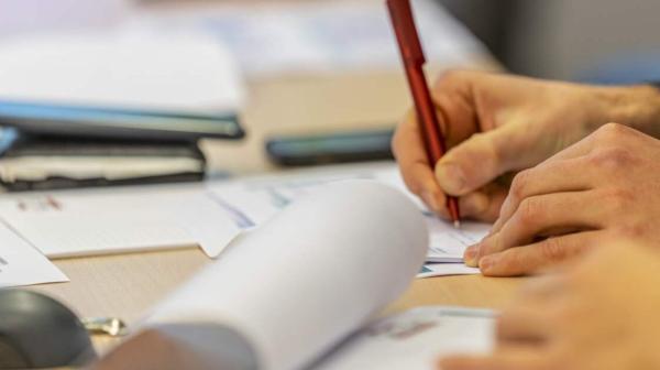 Fortbildungsszene an einem Tisch mit Papierunterlagen