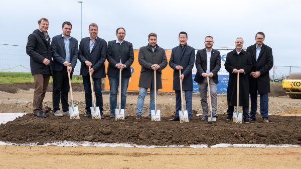 Große Männergruppe mit Spaten vor Spatenstich