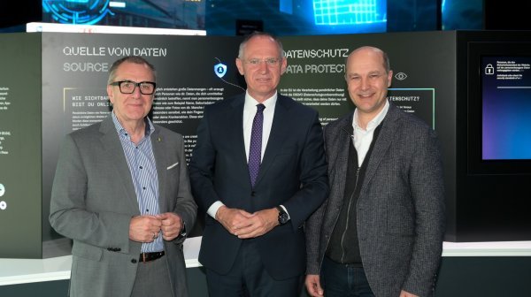 Drei Personen stehen für Gruppenfoto nebeneinander