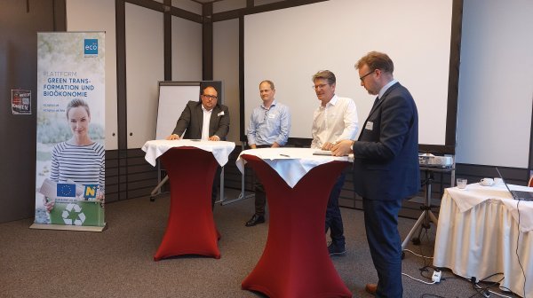 Vier Personen stehen bei Stehtischen