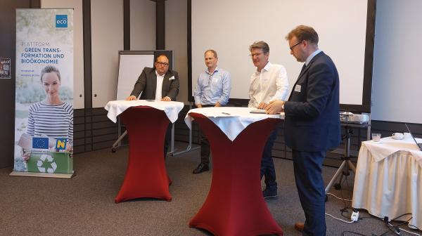 Vier Personen stehen bei Stehtischen