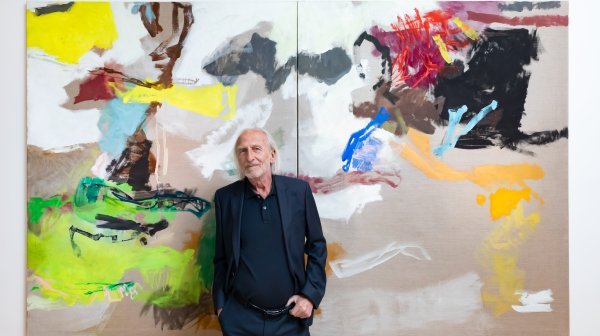 Künstler Wilhelm Drach steht vor seinem Werk