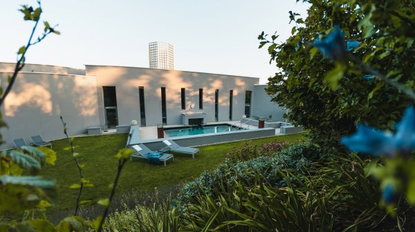 Ein Gebäudekomplex mit einem Pool im Vordergrund 