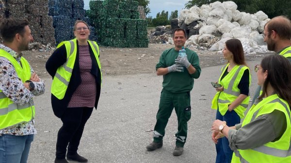 Personen in Warnwesten stehen nebeneinander