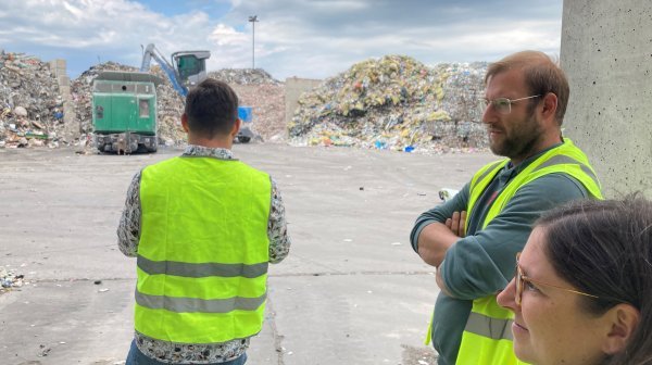 Personen in Warnwesten und Müllberge