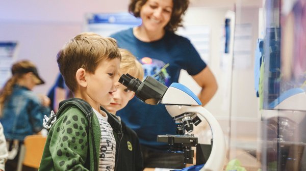 2 Burschen schauen in ein Mikroskop