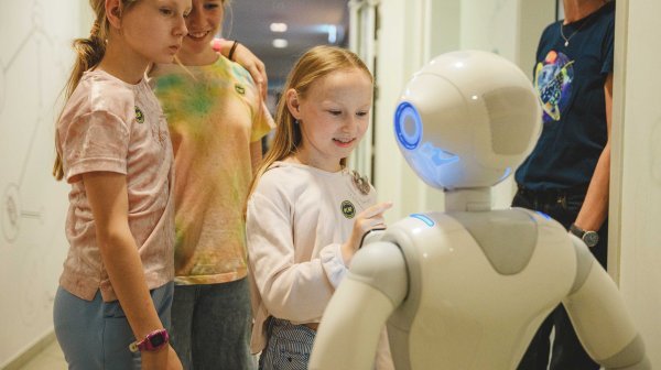Kinder bedienen einen kleinen humanoiden Roboter