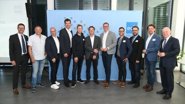 Großes Gruppenbild vor einer ecoplus Rückwand in einem Firmengebäude