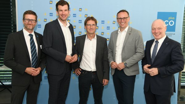 5 Männer stehen vor einer ecoplus Rückwand und schauen in die Kamera