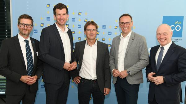 5 Männer stehen vor einer ecoplus Rückwand und schauen in die Kamera