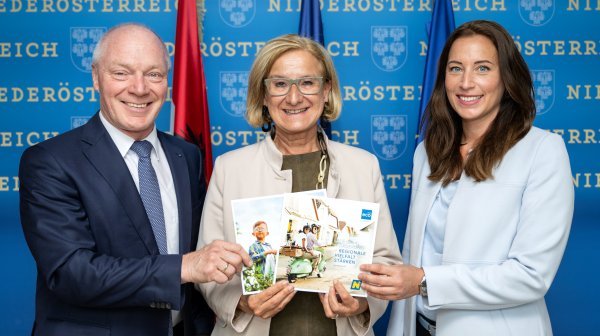 Drei Personen halten Broschüren
