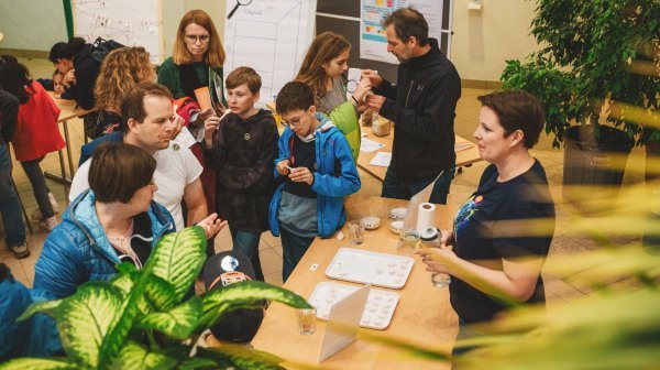Leute tummeln sich vorm Stand des Lebensmittel Cluster