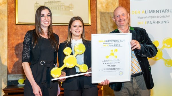 Drei Personen halten Preis