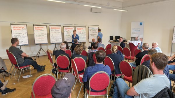 Personen sitzend und stehend im Workshopraum