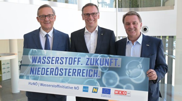 Drei Personen halten Schild