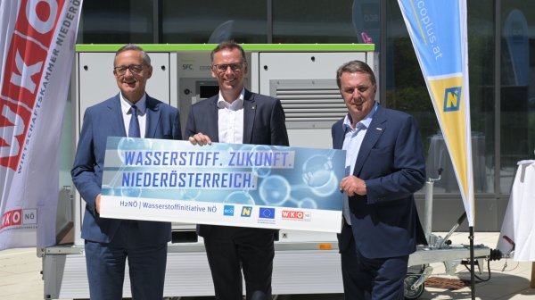 Drei Personen halten Schild