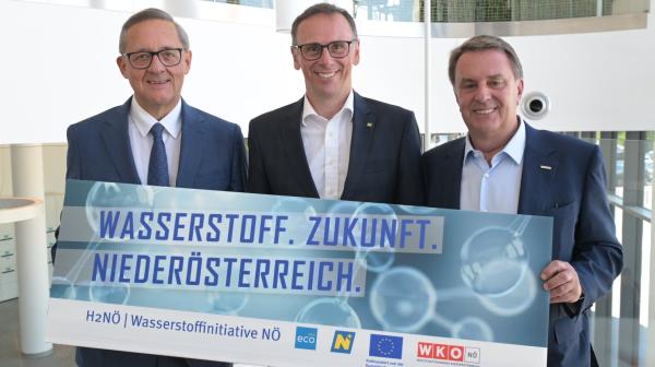 Drei Personen halten Schild