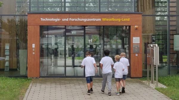 Vier Kinder hören Vortragendem zu