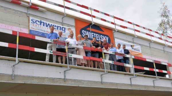 Großes Gruppenfoto vor Rohbau - anlässlich Gleichenfeier Firma Schweng