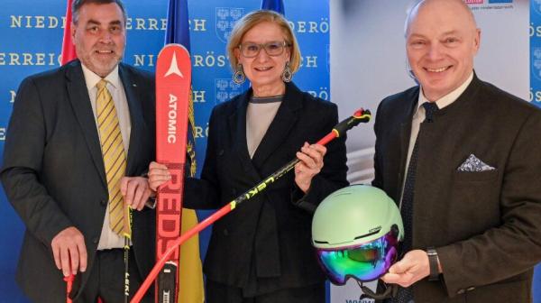 drei Personen stehen in einer Reihe und halten einen Ski