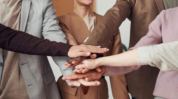 mehrere Personen halten Hände in der Mitte zusammen