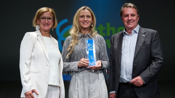 Drei Leute stehen in einer Reihe mit einem Siegertrophäe