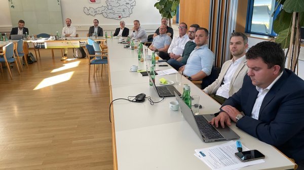 Viele Personen sitzen gemeinsam in einem Vortragsraum