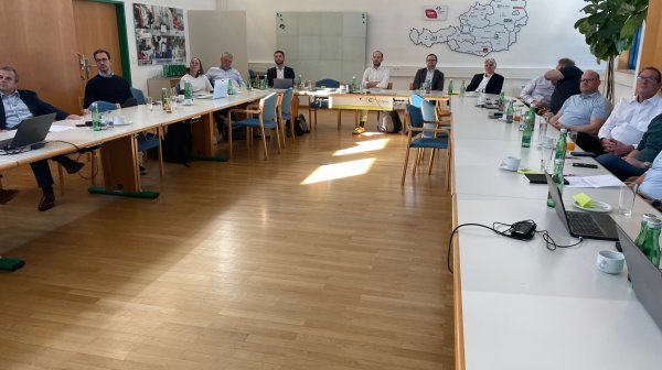 Viele Personen sitzen gemeinsam in einem Vortragsraum