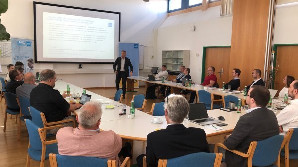 Viele Personen sitzen gemeinsam in einem Vortragsraum