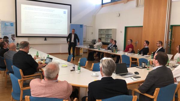 Viele Personen sitzen gemeinsam in einem Vortragsraum