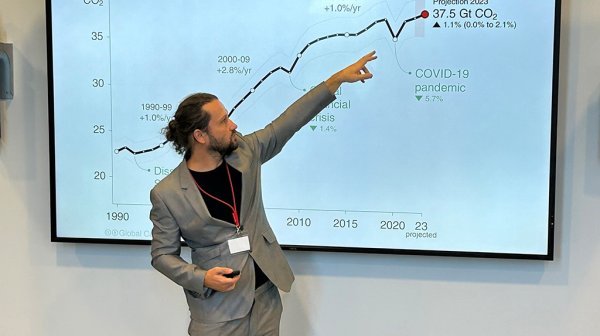 Vortragender zeigt auf PowerPoint Folie