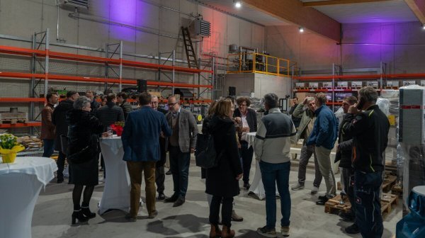 viele Personen stehen versammelt in einer Halle